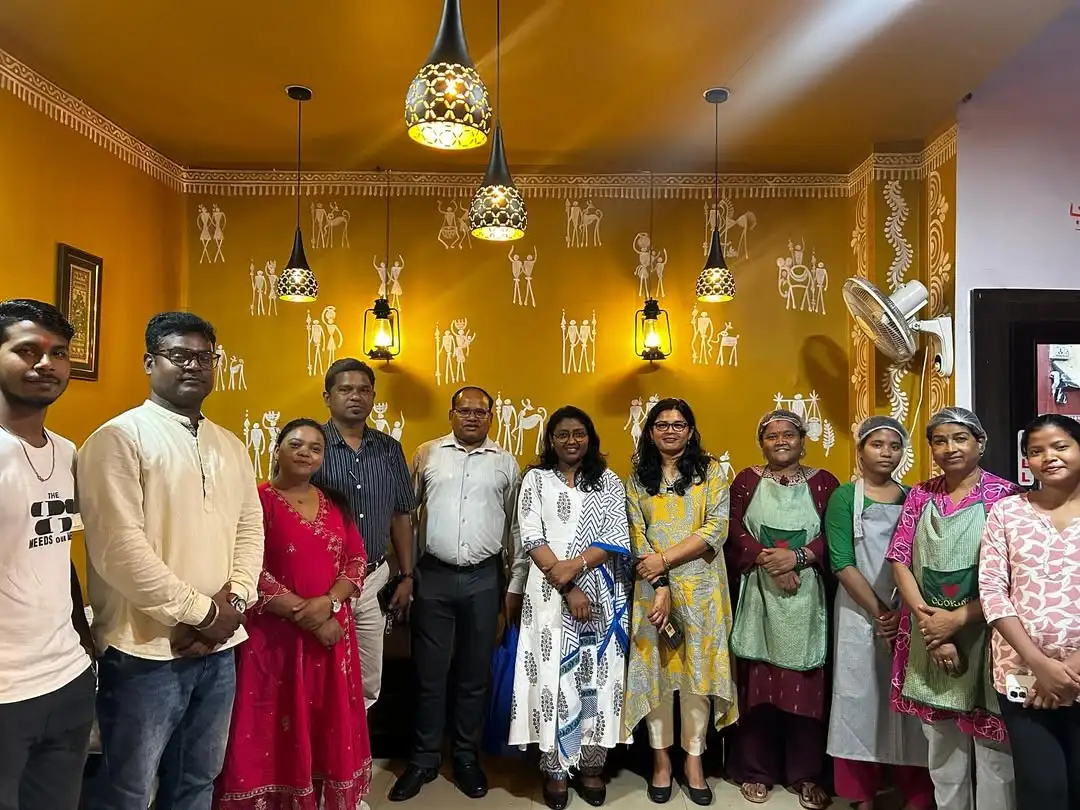 Guests group photo at JOMHA Restaurant with Warli art decorated walls