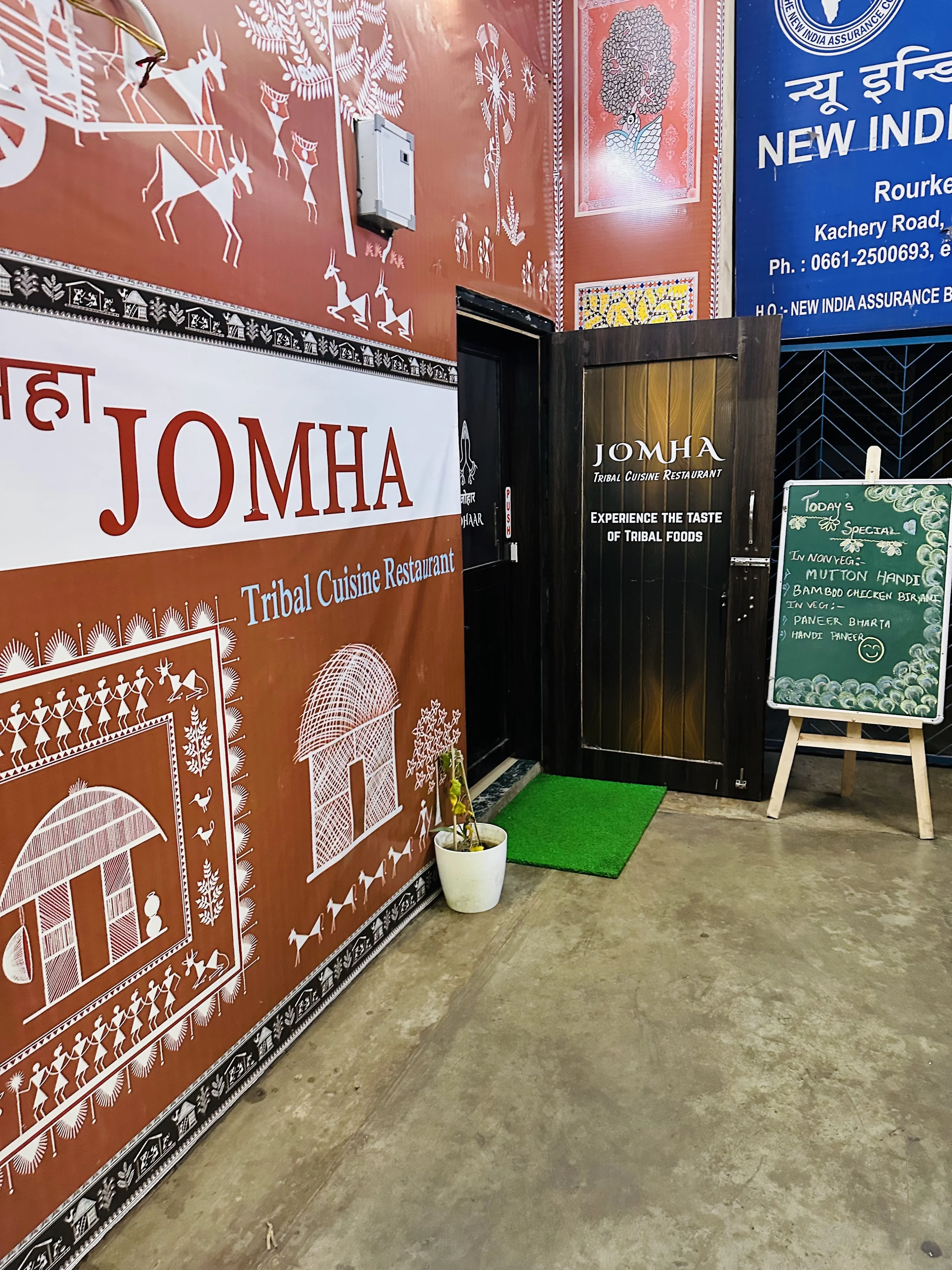 JOMHA Restaurant exterior entrance with tribal Warli art signage and menu board